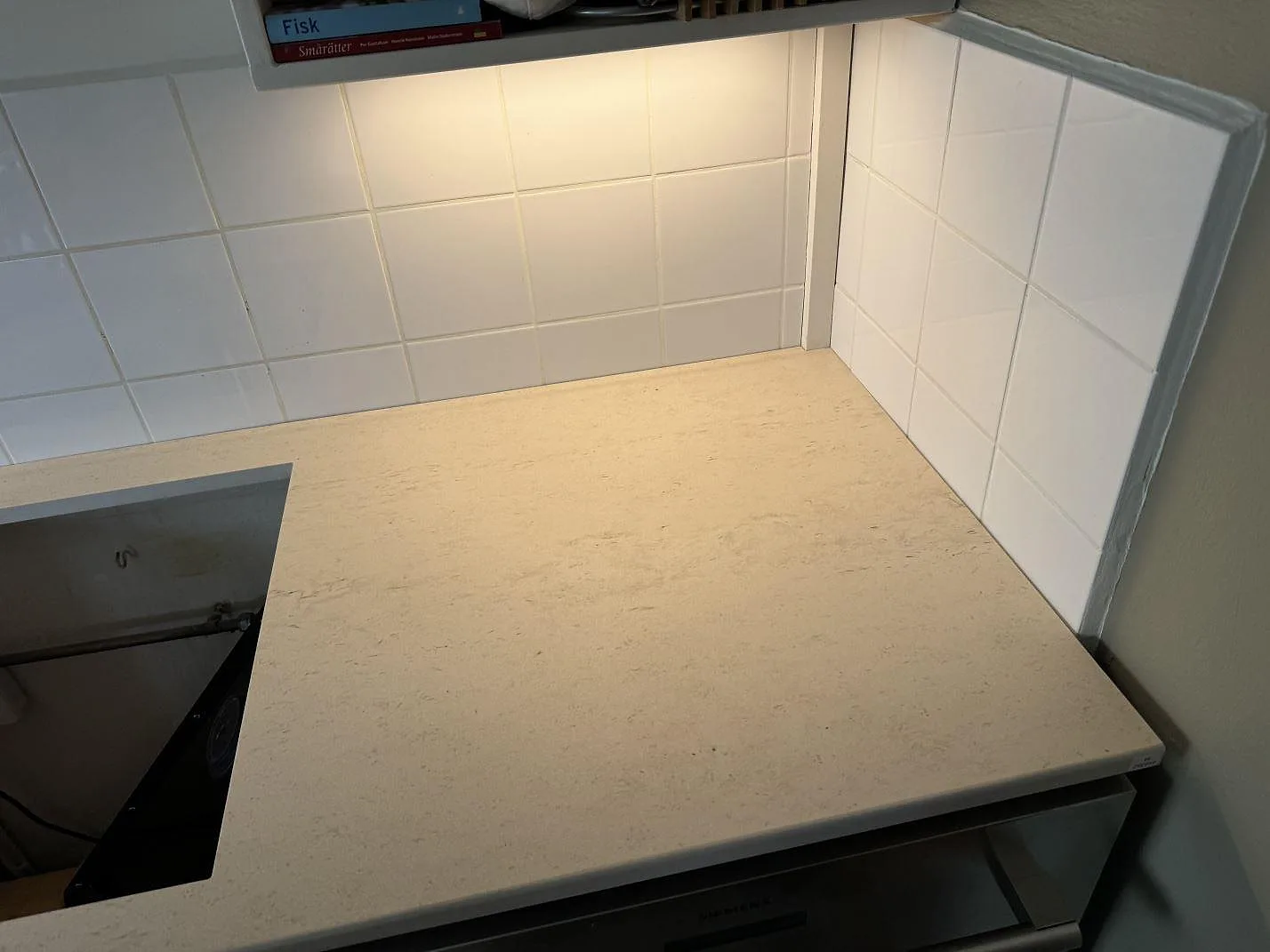 Närbild på matt köksbänkskiva i Dekton Danae, keramik, med ljus ådring och hällöppning i ett kök i Malmö.