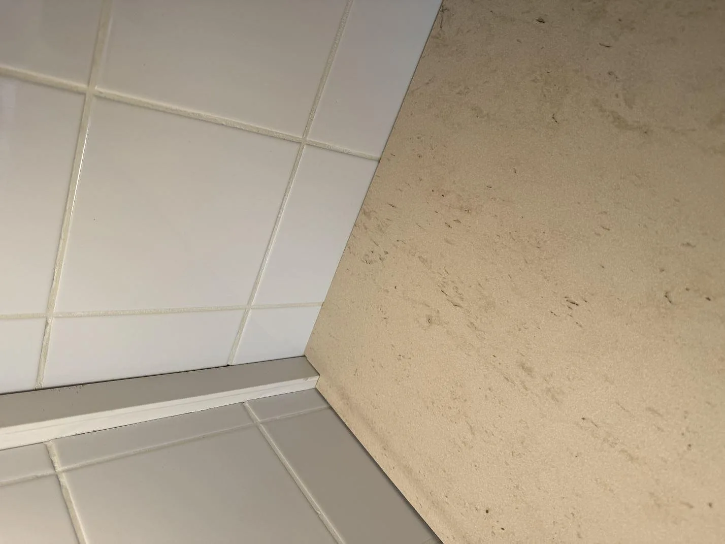 Detaljbild av kanten och den matta ytan i Dekton Danae, keramik, intill kakel i ett kök i Malmö.