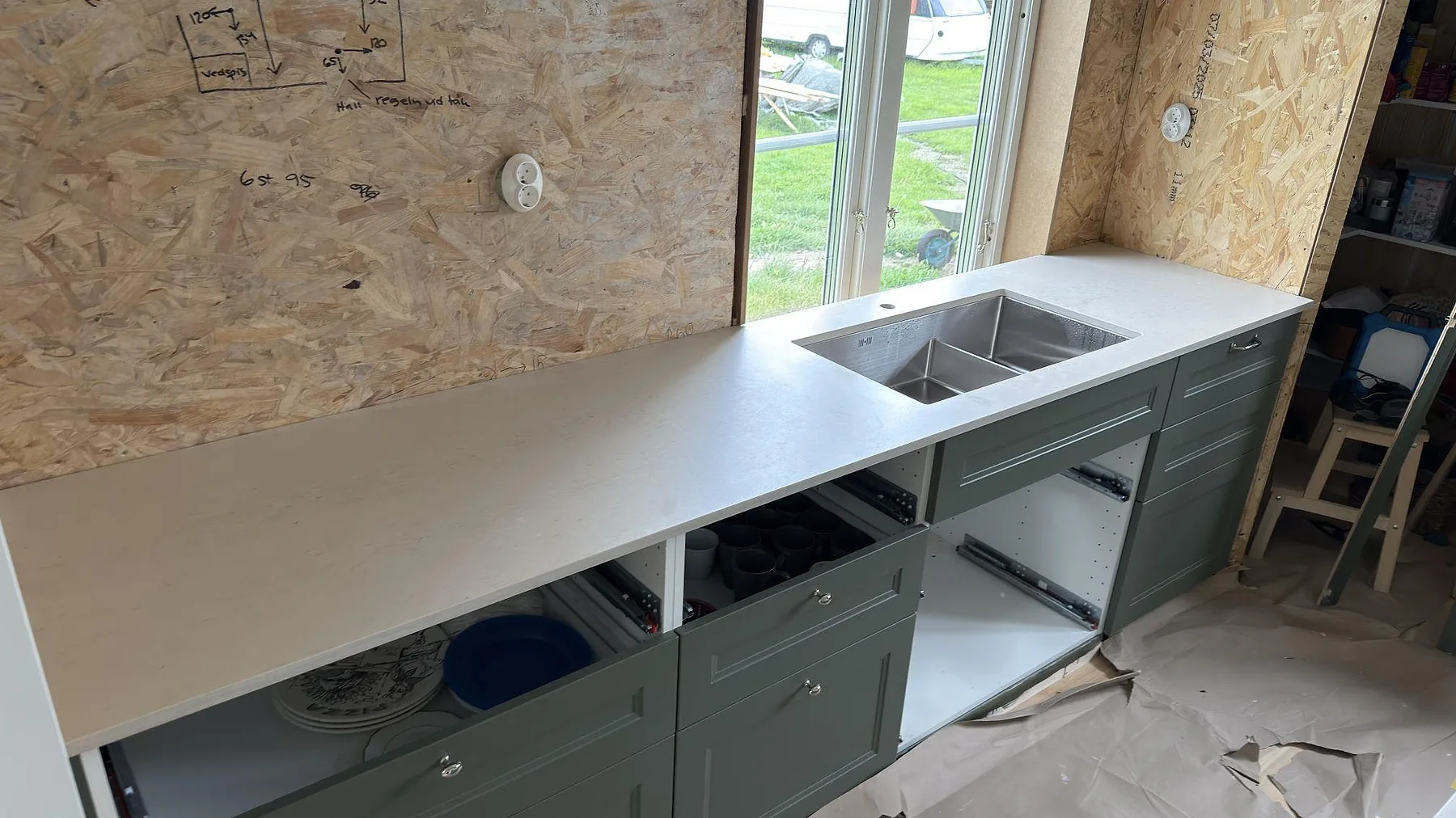 Rak köksbänk i matt Dekton Danae med underlimmad rostfri diskho och ljus ådring under montering i Österbybruk.