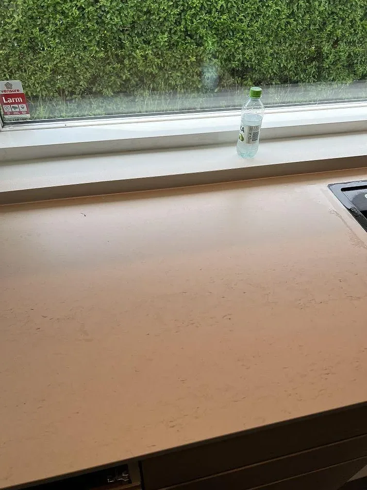 Matt Dekton Danae som köksbänkskiva längs fönster med trädgårdsutsikt i Trelleborg.