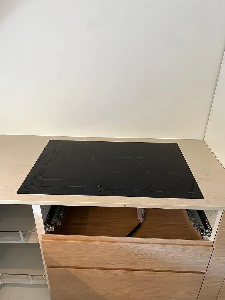 Svart häll monterad i en matt köksbänkskiva i Dekton Danae med trästommar i Trelleborg.