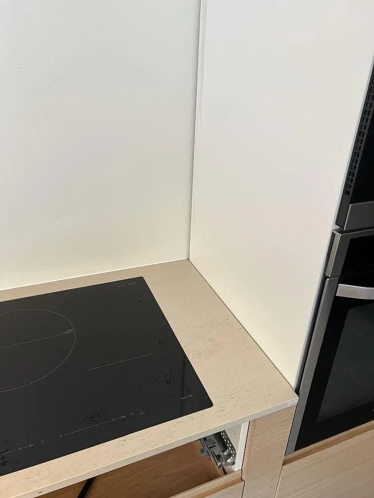 Närbild på svart häll och ljus matt Dekton Danae med beige ådring i ett kök i Trelleborg.