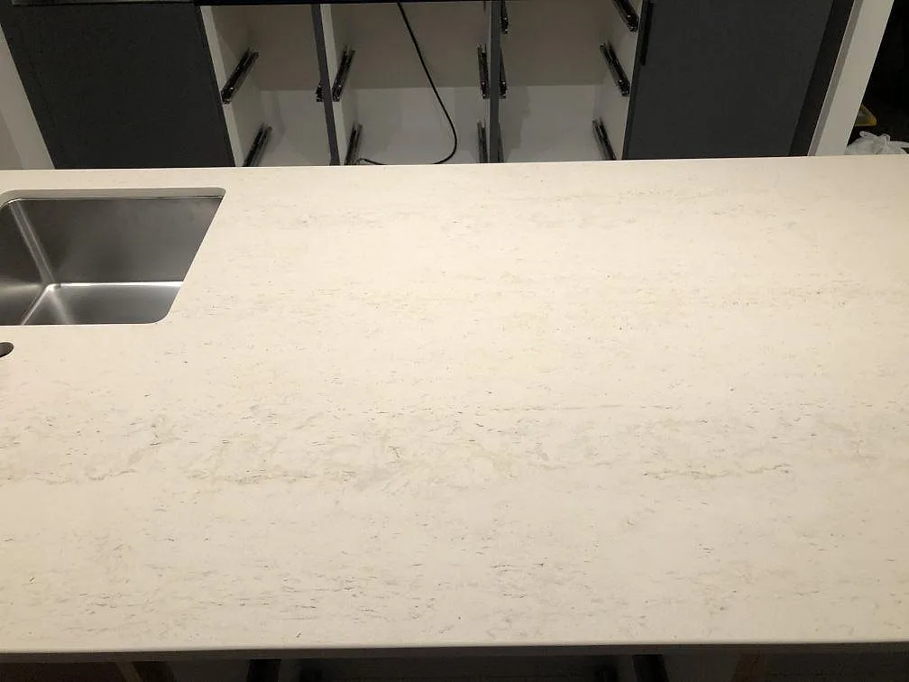 Köksö i Dekton Danae med underlimmad rostfri diskho och mjuk ljus ådring, matt yta, i ett kök i Værløse.