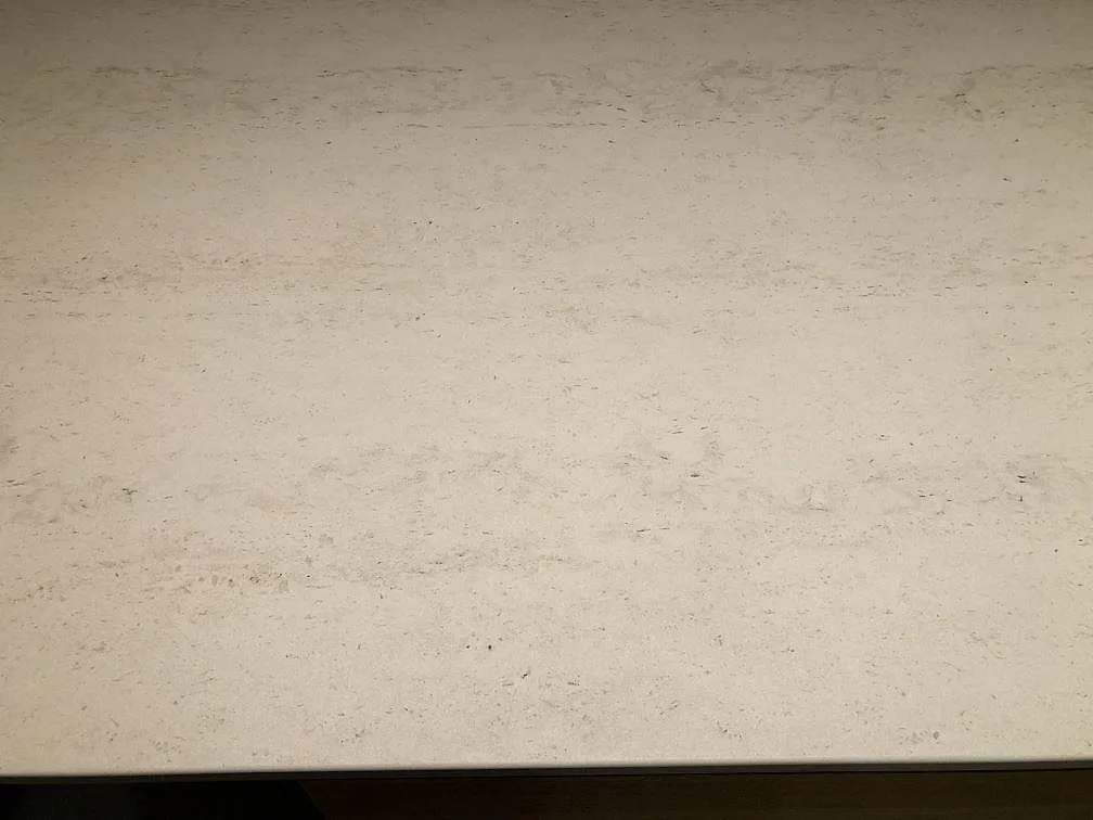 Närbild på den varmvita, matta ytan i Dekton Danae med diskret ådring på en köksbänkskiva i Værløse.