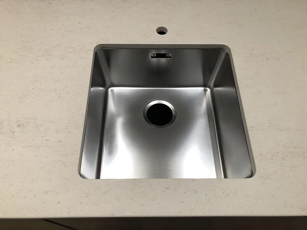 Underlimmad rostfri diskho i en matt Dekton Danae köksbänkskiva i Værløse, sedd ovanifrån.