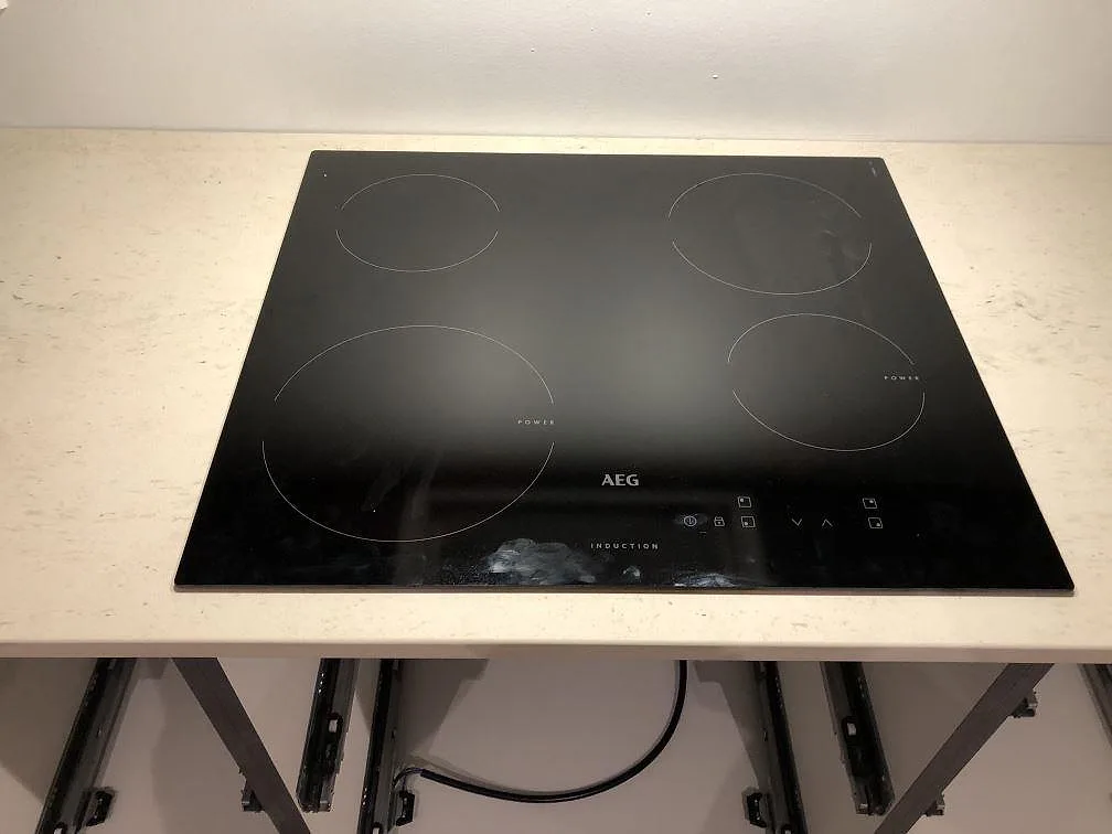 AEG induktionshäll placerad på en köksbänkskiva i Dekton Danae under montering i ett kök i Værløse.