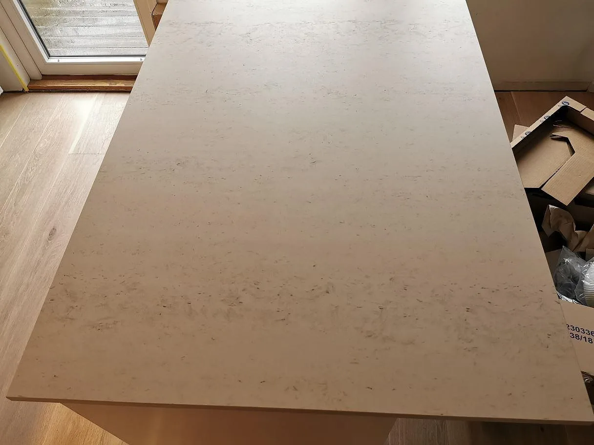 Köksö i Dekton Danae sedd ovanifrån, matt yta med mjuk ljus ådring, i ett kök i Vellinge.