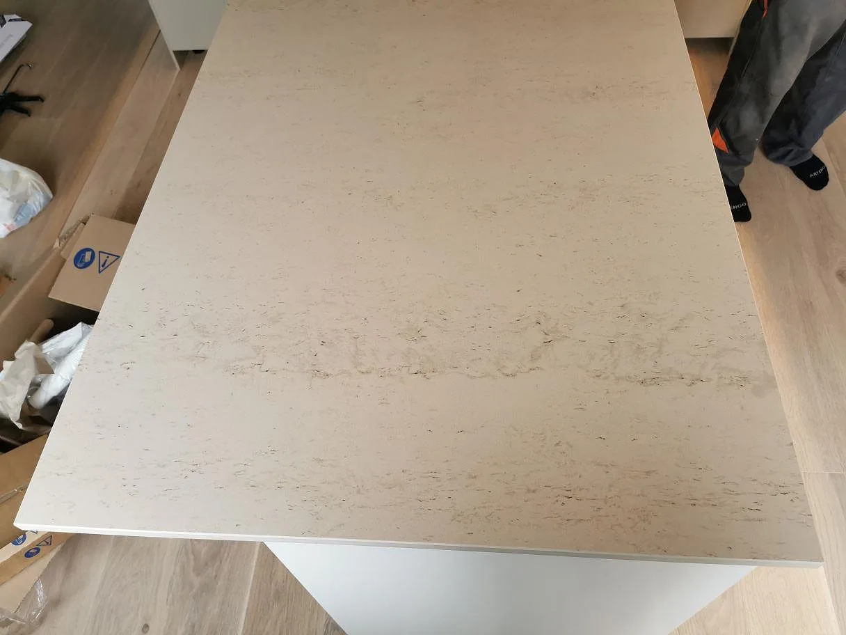 Köksö i Dekton Danae sedd ovanifrån under montering, matt warm greige yta, i ett kök i Vellinge.
