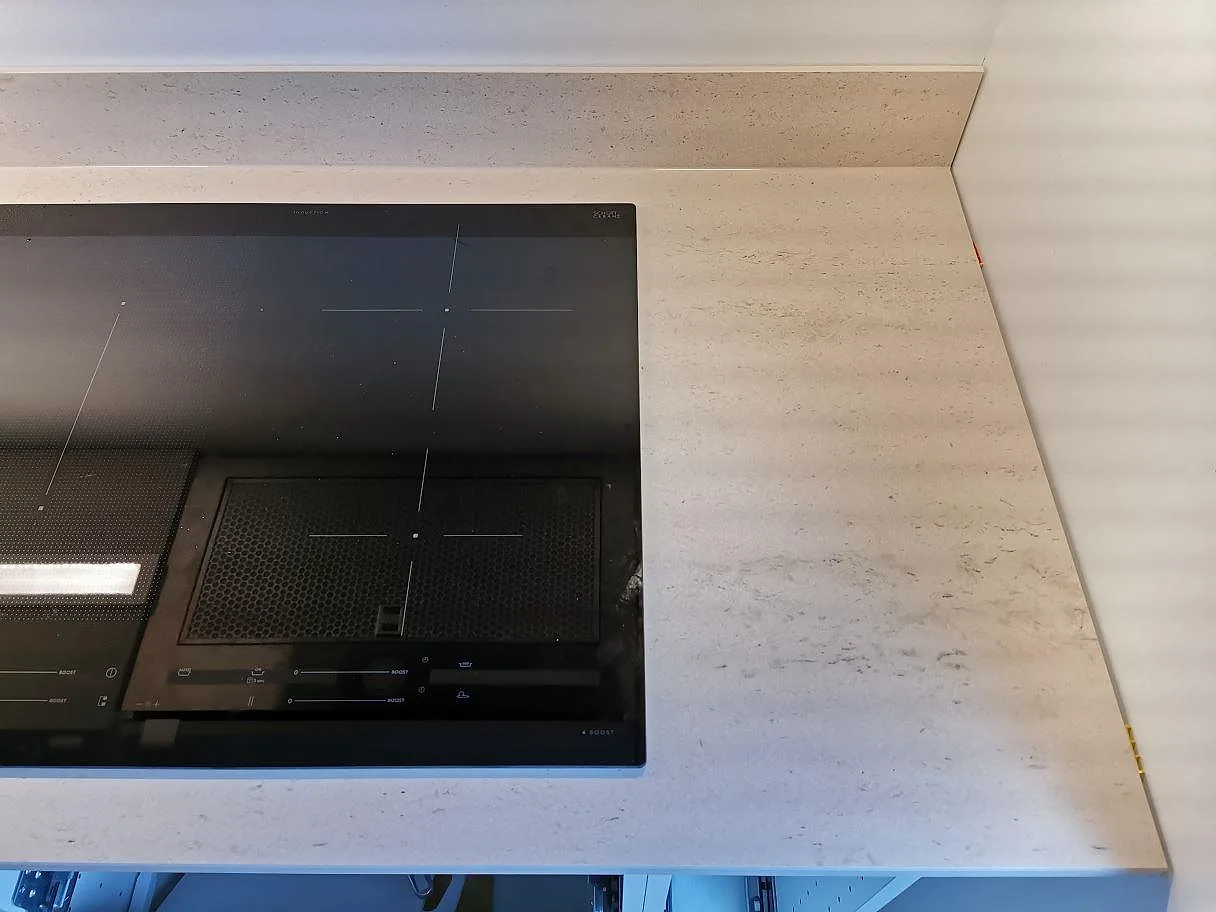 Övermonterad induktionshäll i en köksbänkskiva i Dekton Danae, matt med mjuk ådring, i ett kök i Vellinge.