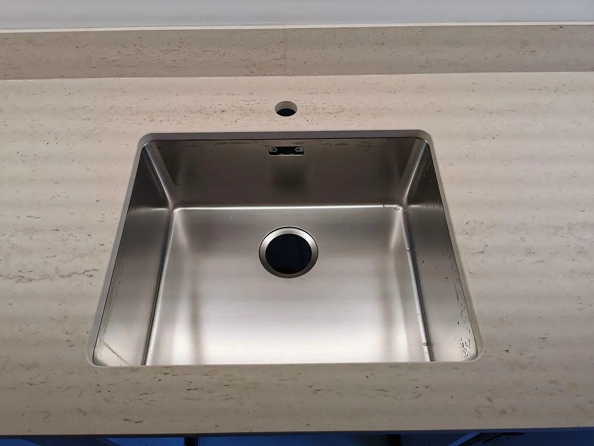 Underlimmad rostfri diskho i en köksbänkskiva i Dekton Danae, matt, i ett kök i Vellinge.