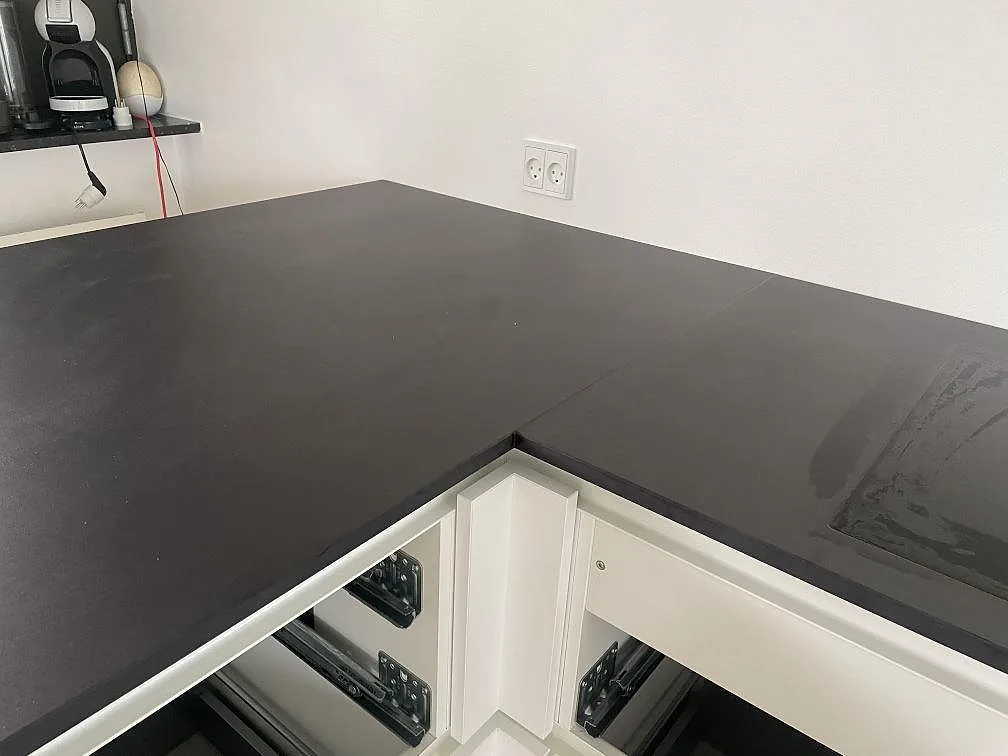 Insida av L-formad köksbänkskiva i matt Dekton Domoos keramik med skarv och hällzon i Greve.