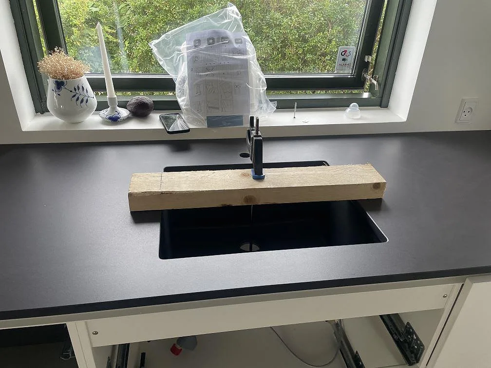 Diskbänk i mörk matt Dekton Domoos keramik med svart underlimmad diskho och svart blandare i ett kök i Greve.