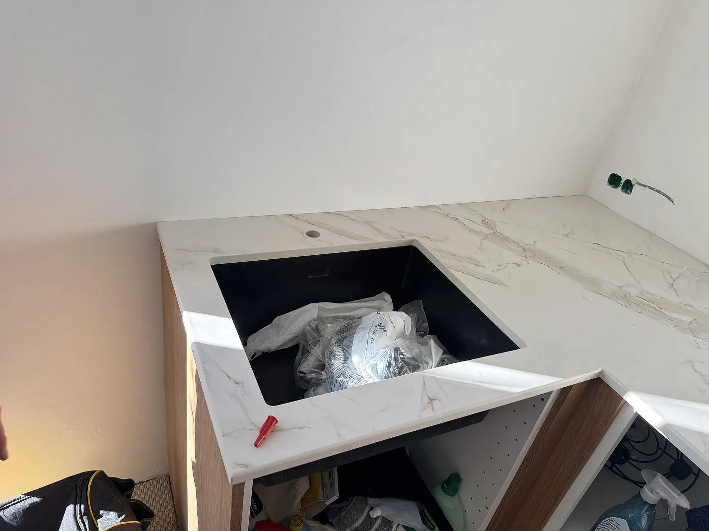 Underlimmad svart kompositdiskho med borrat blandarhål i en köksbänkskiva av Dekton Entzo keramik i Frederikssund.