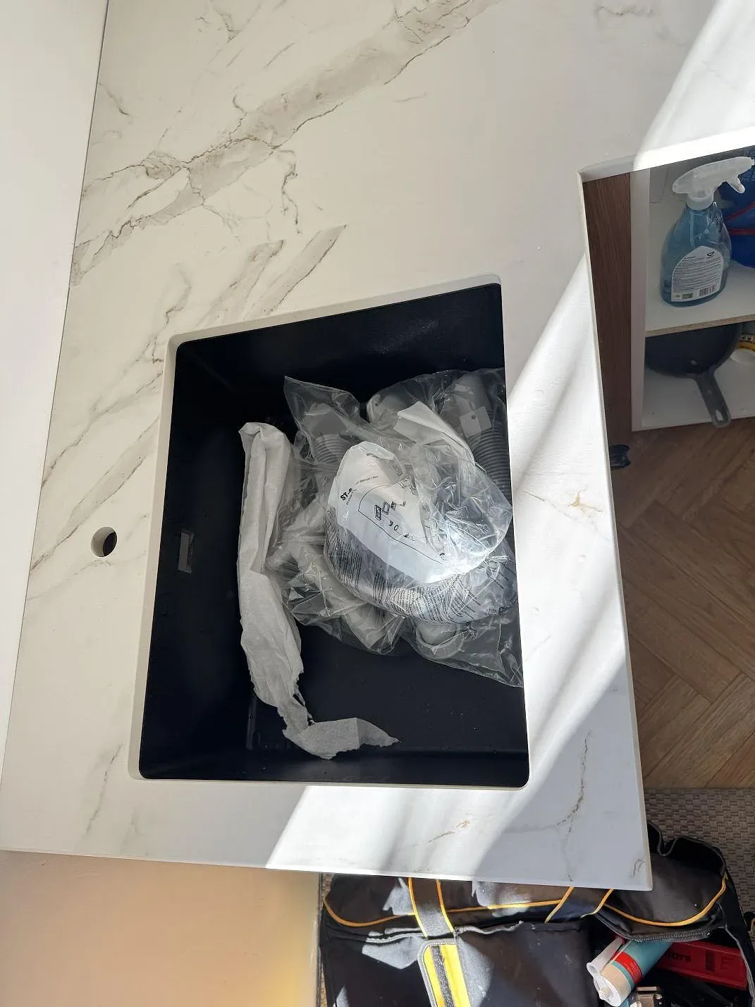 Detalj av underlimmad diskho och tapphål i matt Dekton Entzo köksbänkskiva, sedd ovanifrån, i ett kök i Frederikssund.