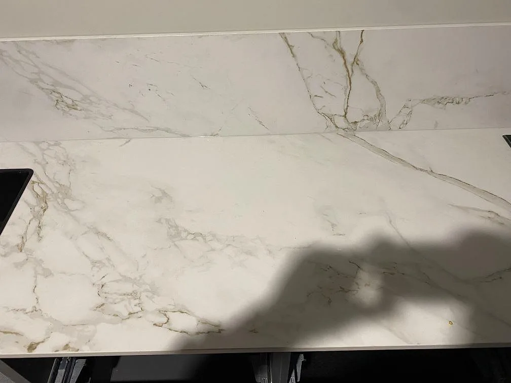 Detalj av den ljusa ådringen i matt Dekton Entzo på köksbänkskiva och stänkskydd i Göteborg.