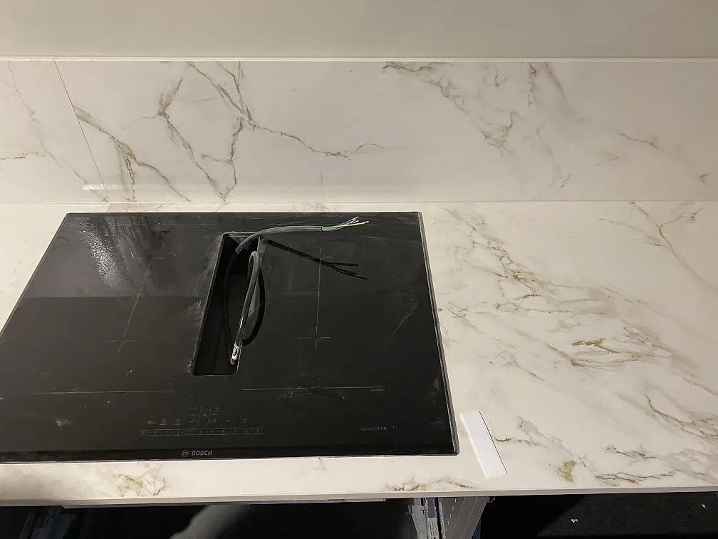 Svart häll monterad i matt Dekton Entzo köksbänkskiva med låg stänkkant i Göteborg.