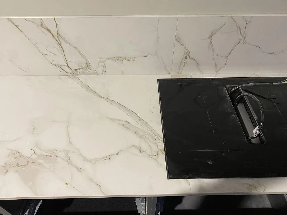 Ovanvy av matt Dekton Entzo bänkskiva med svart häll och marmorerad stänkskiva i Göteborg.