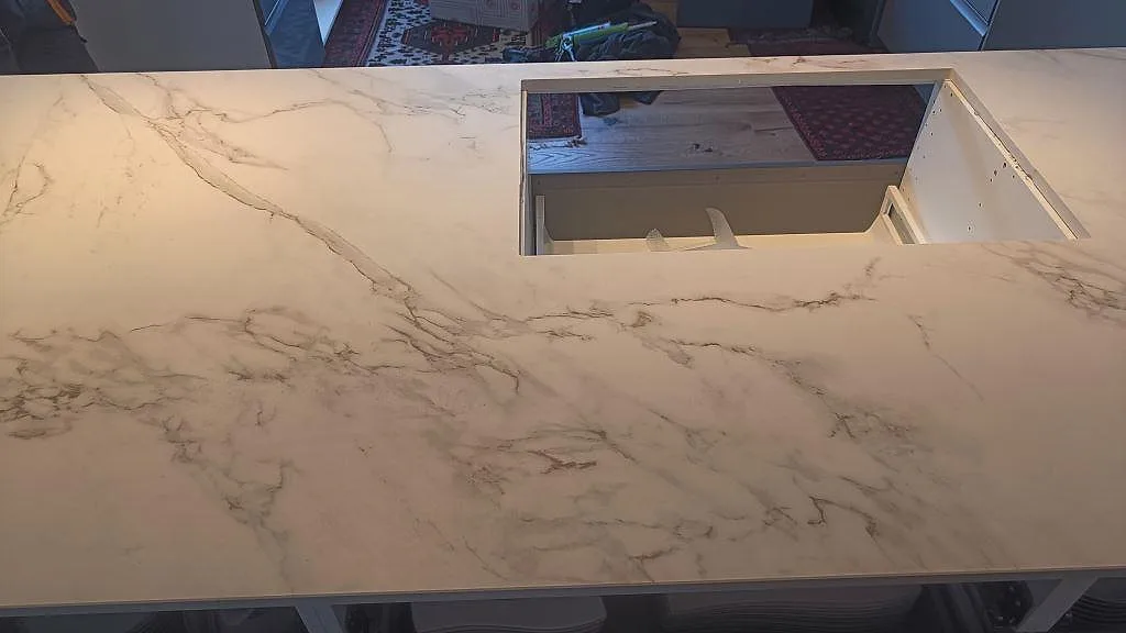 Detalj av köksö i matt Dekton Entzo med stor urtagning och sammanhängande ådring i ett kök i Häljarp.