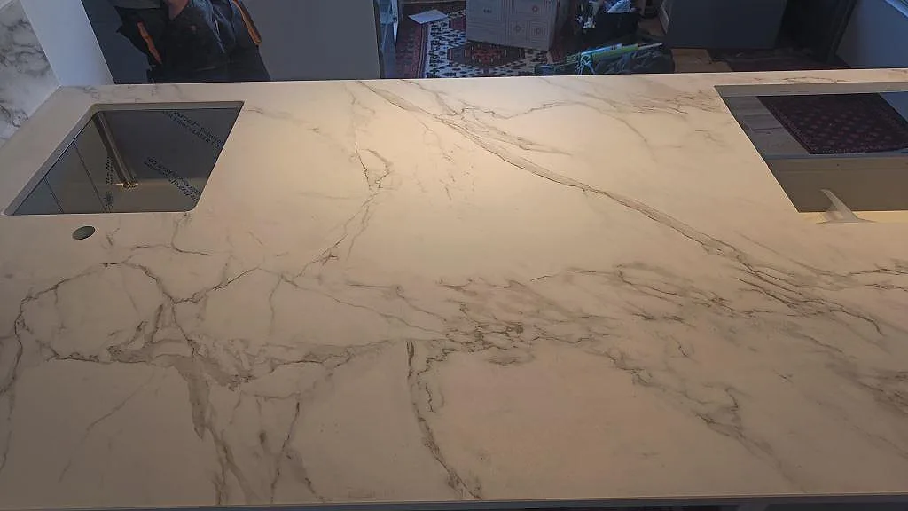 Närbild på matt Dekton Entzo med svart underlimmad diskho, stor öppning i arbetsytan och markerad ådring i Häljarp.