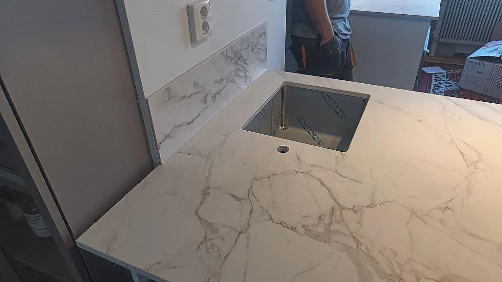Matt Dekton Entzo som köksbänkskiva med svart underlimmad diskho och låg stänkkant i samma keramik i Häljarp.