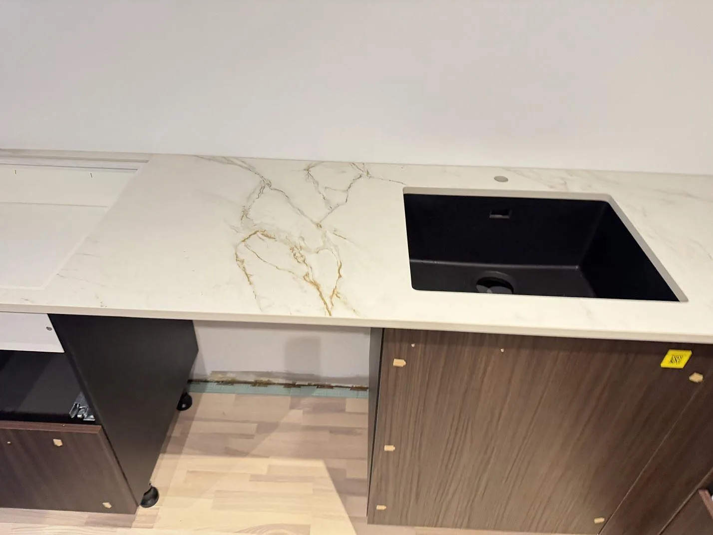 Köksbänkskiva i matt Dekton Entzo med underlimmad svart kompositdiskho och avrinningsspår frästa i keramiken i ett kök i Hedehusene.