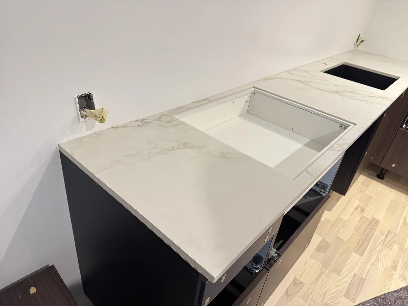 Fristående halvö med köksbänkskiva i Dekton Entzo keramik, matt yta med urtagning och en svart underlimmad diskho i ett kök i Hedehusene.