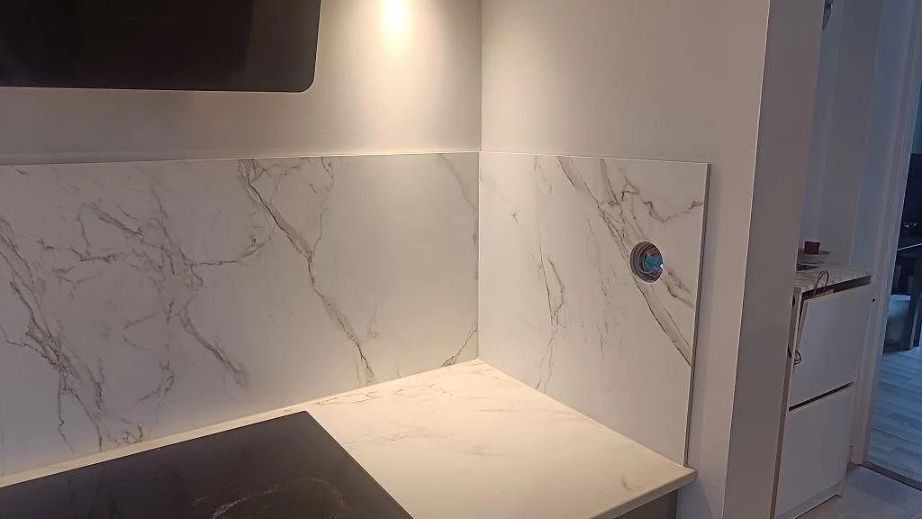 Hällzon i matt Dekton Entzo med mönsterpassad väggskiva och vit marmorerad arbetsyta i Jönköping.