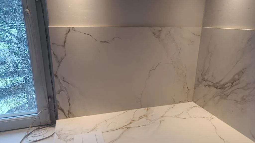 Fönstersida med köksbänkskiva och stänkskydd i matt Dekton Entzo med markerad grå ådring i Jönköping.