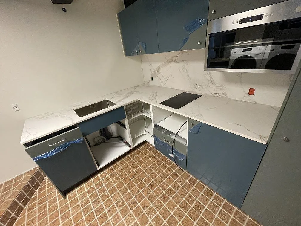 Köksbänkskiva i vit matt Dekton Entzo keramik med rostfri diskho, svart häll och blå köksfronter i København K.