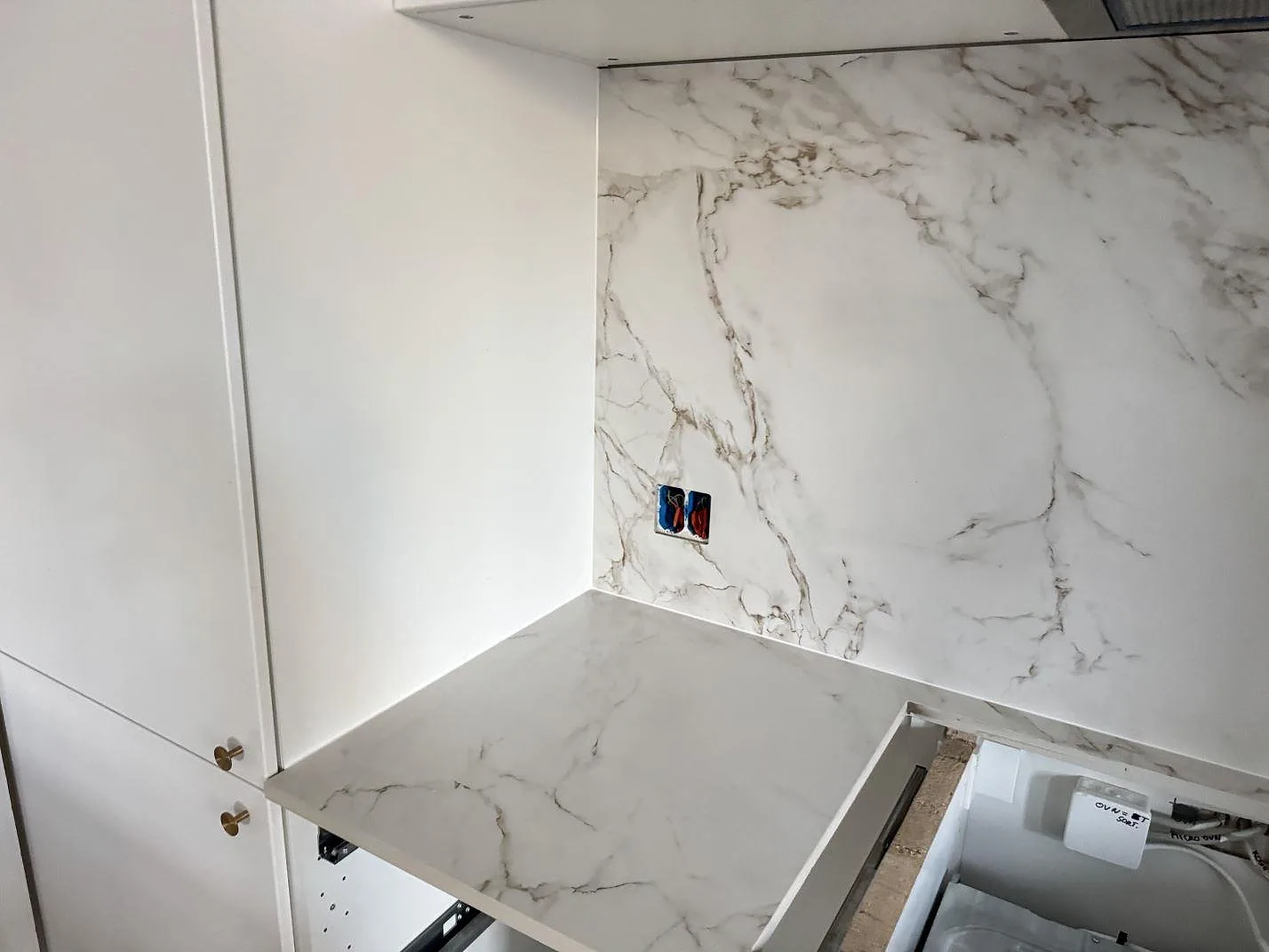 Vänster del av köket med bänkskiva och hög väggbeklädnad i matt Dekton Entzo keramik vid diskzonen i København NV.