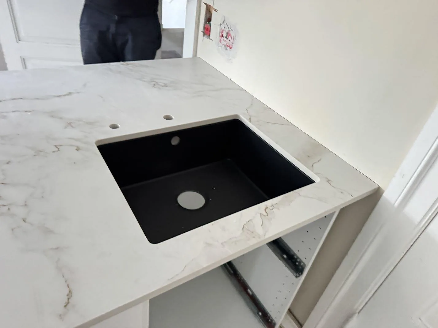 Närbild på svart diskho i en matt Dekton Entzo bänkskiva med ljus marmorering och borrhål för blandare i København NV.
