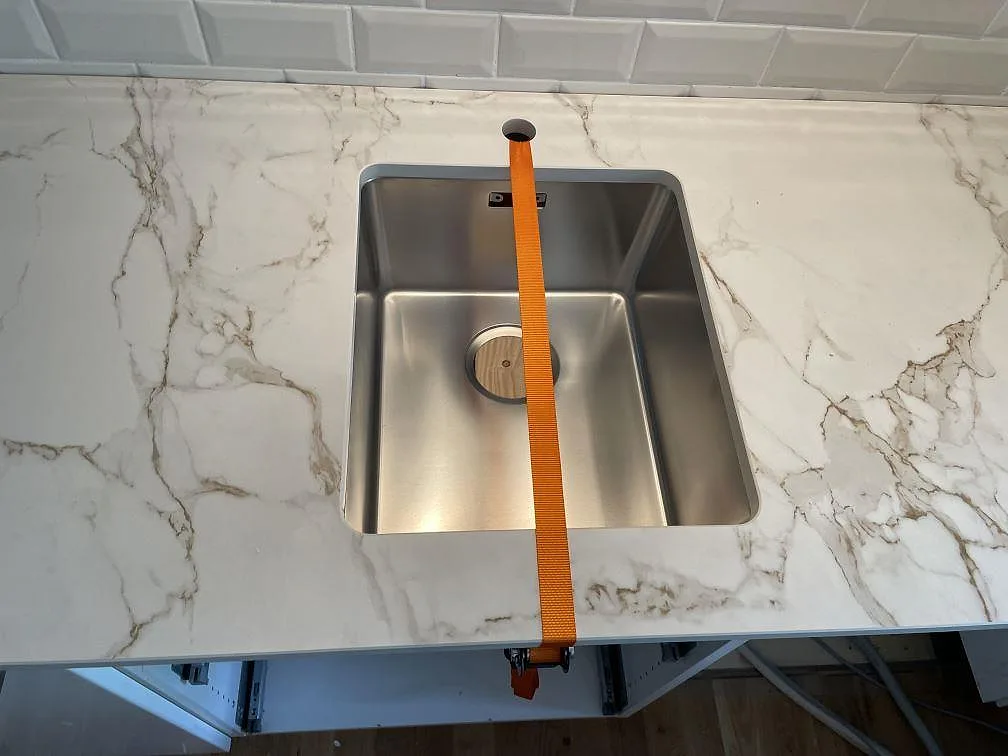 Diskhodetalj i matt Dekton Entzo keramik med rostfri underlimmad ho och tydlig ådring i ett kök i Malmö.