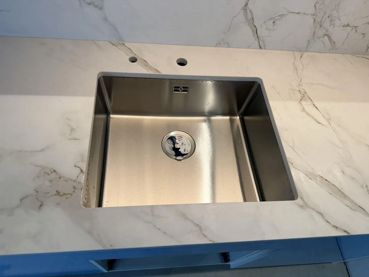 Underlimmad rostfri diskho i en matt Dekton Entzo köksbänkskiva med marmorerad ådring i Mölnlycke.