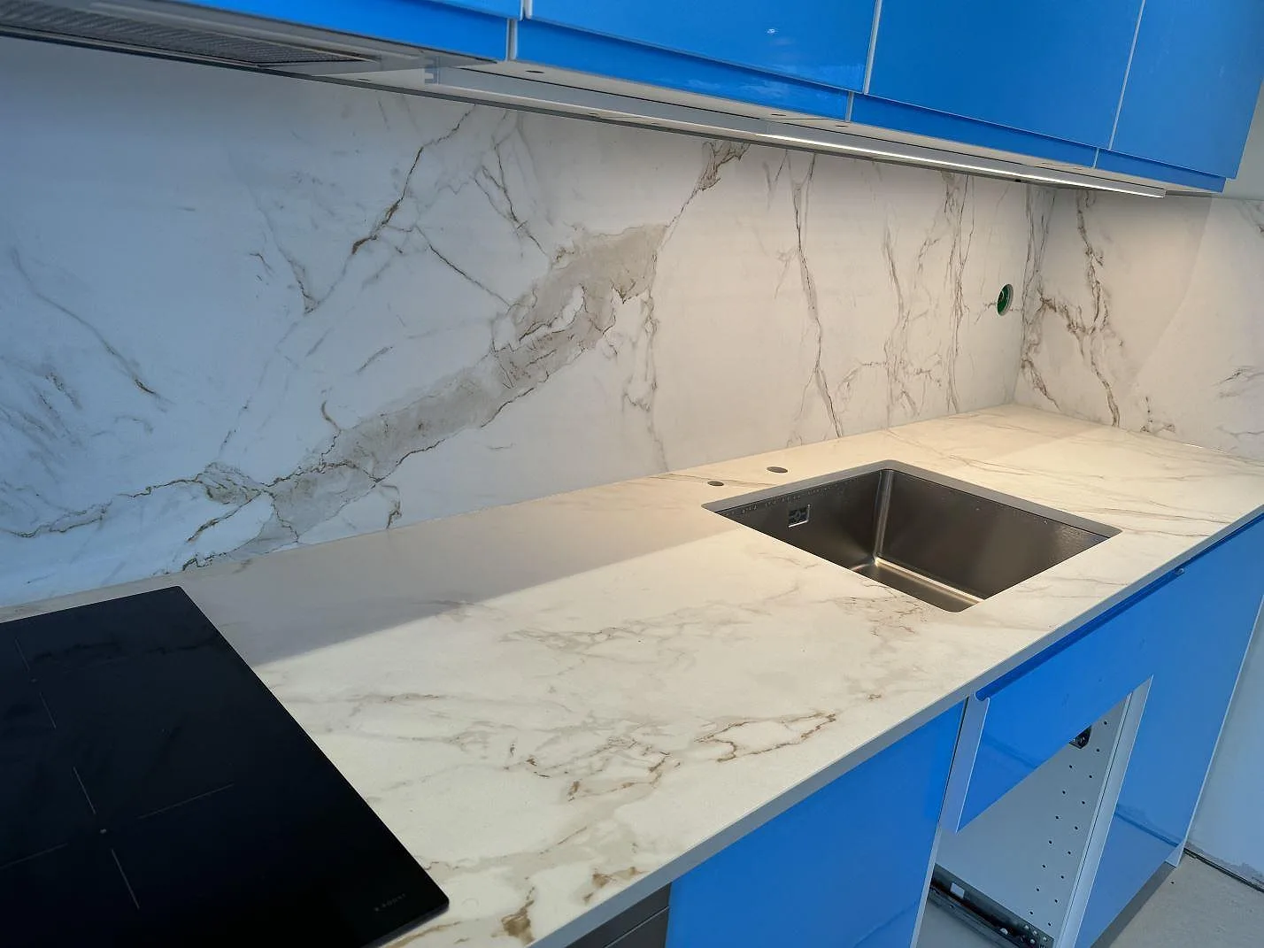 Närbild av matt Dekton Entzo som köksbänkskiva och väggbeklädnad med underlimmad diskho i Mölnlycke.
