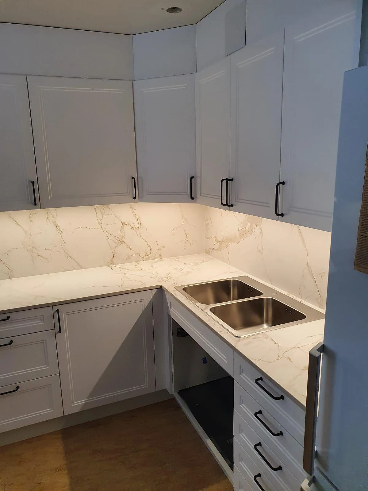 Underlimmad rostfri dubbelho i en matt Dekton Entzo köksbänkskiva med matchande stänkskydd i Rönninge.
