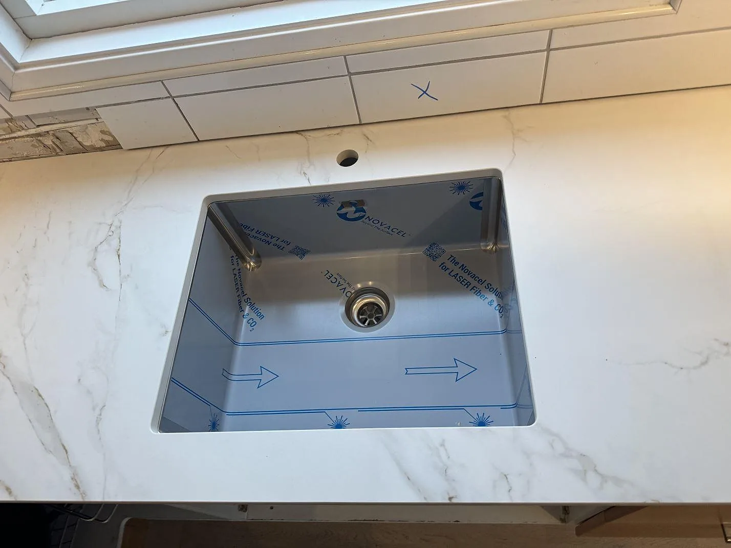 Närbild på diskho i köksbänkskiva av matt Dekton Entzo, vit keramik med grå ådring i Sätila.