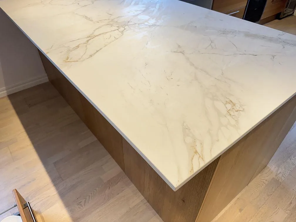 Närbild av köksö i matt Dekton Entzo, med ljus keramisk yta och tydlig grå ådring i Sätila.