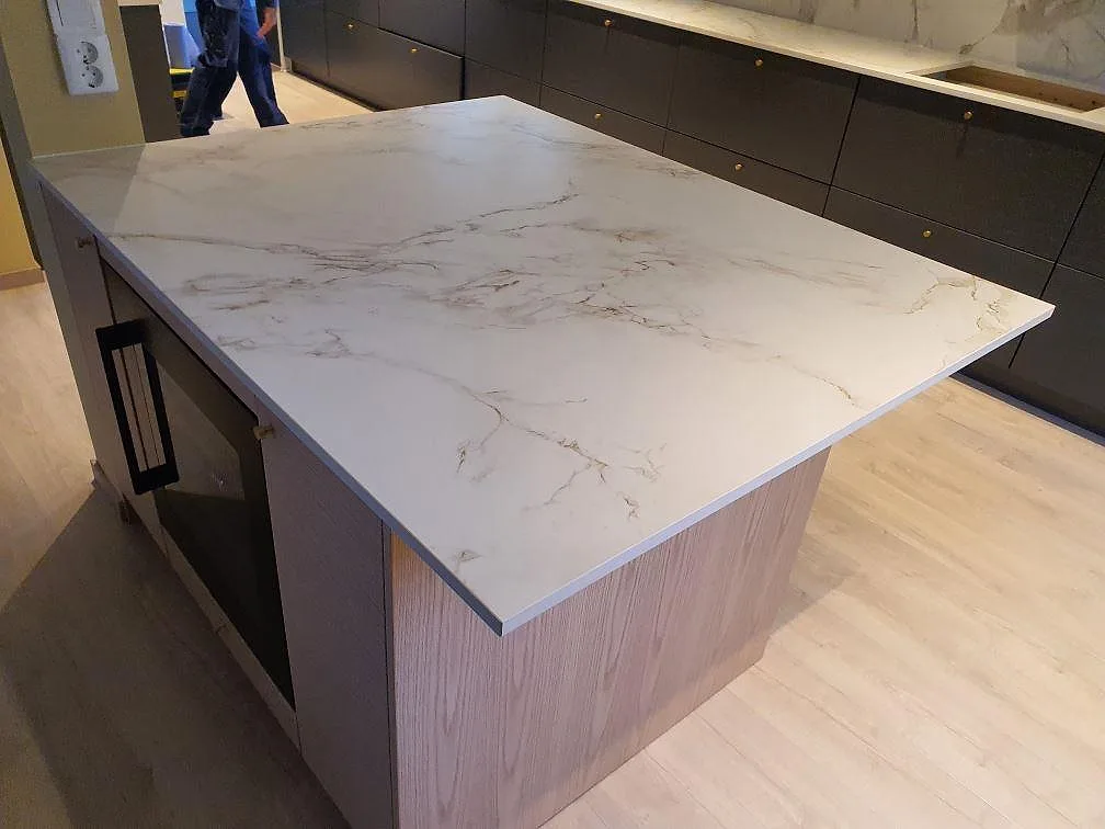 Närbild på köksö med bänkskiva i Dekton Entzo Matt, vit keramik med grå och varma ådror, monterad i Sundbyberg.