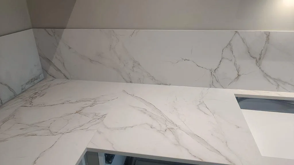 Matt Dekton Entzo på väggbänk med matchande stänkskydd och öppning i stenen under köksmontering i Trelleborg.