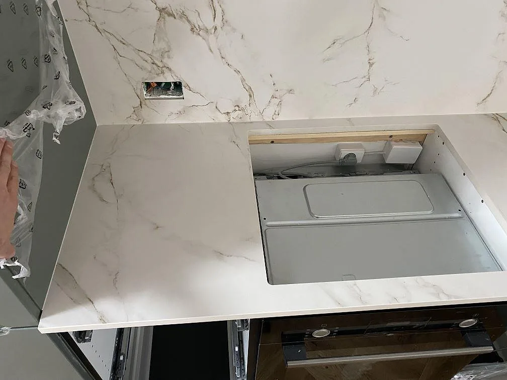 Detalj av matt Dekton Entzo bänkskiva i keramik med öppning vid hällplats och matchande stänkskydd i Valby.