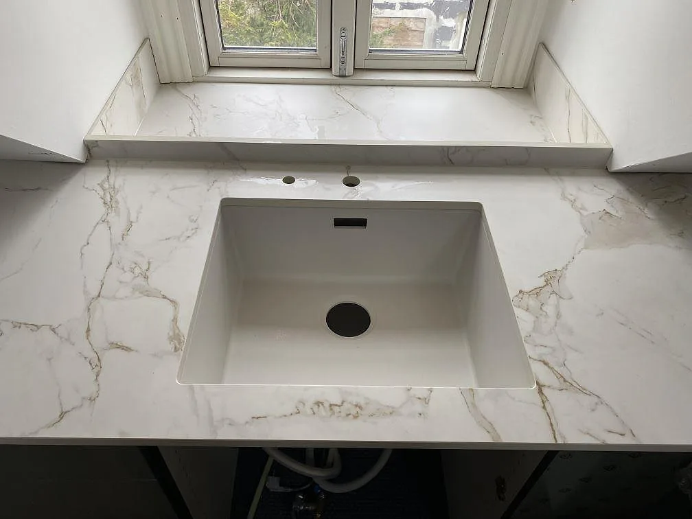 Närbild på diskho i en matt Dekton Entzo köksbänkskiva av keramik med matchande fönsterbänk i Valby.