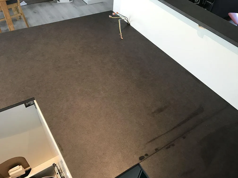 Närbild av brungrå Dekton Eter i Mocka med utskärning i ett vitt kök i Karlshamn.