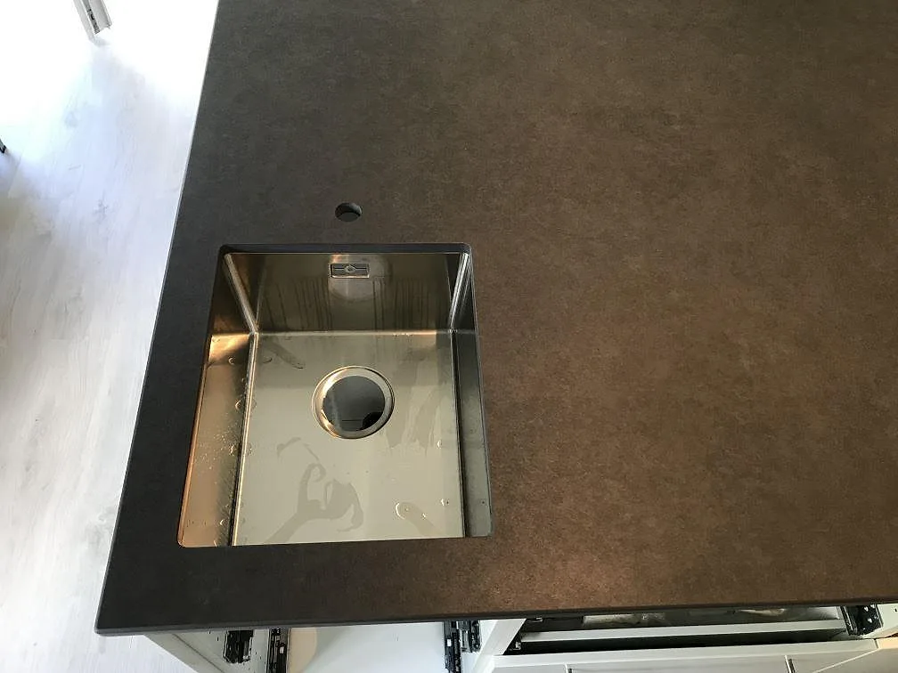 Detalj av diskho i köksbänkskiva av Dekton Eter, Mocka, under montering i Karlshamn.