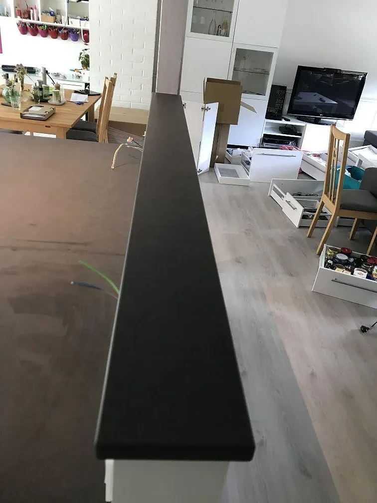 Sidovy av installerad köksbänkskiva i mörk Dekton Eter, Mocka, i ett kök i Karlshamn.
