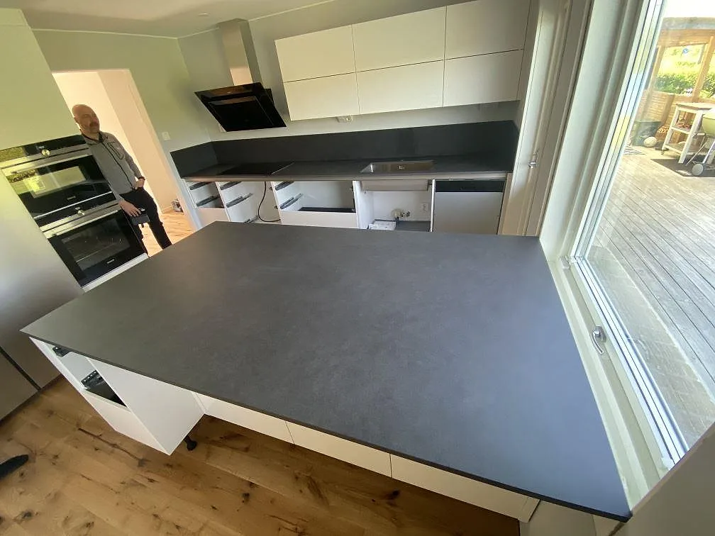 Köksbänkskiva och köksö i Dekton Eter i matt mockafinish i ett kök i Strövelstorp, fotograferat under montering.