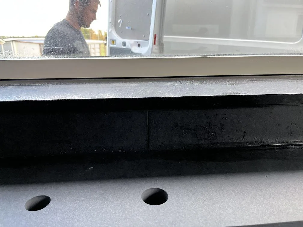 Detaljbild av matt Dekton Eter bänkskiva med runda urtag och stänkskydd vid fönster i Vankiva.
