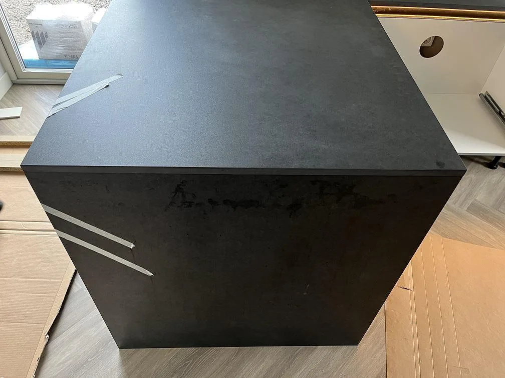 Närbild på köksö med neddraget sidostycke i matt Dekton Eter keramik i Vankiva.