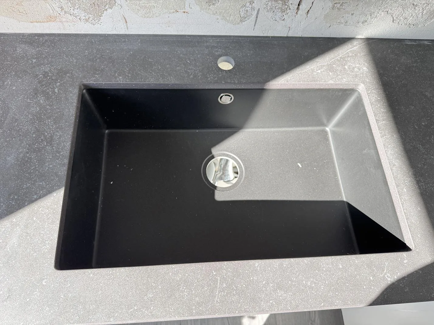 Detalj av svart diskho i matt köksbänkskiva av Dekton Fossil keramik i Arlöv.