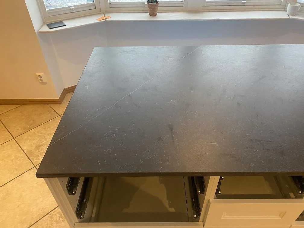 Närbild på den matta ytan i Dekton Fossil med subtil fossilstruktur på köksön i Bara.