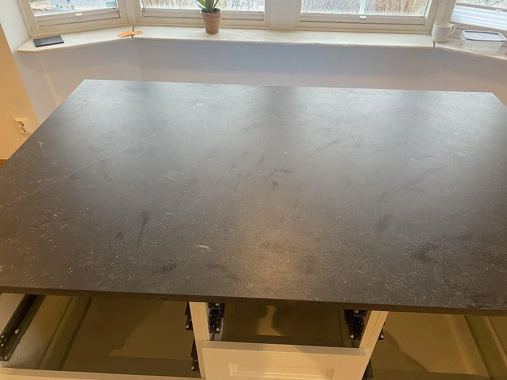 Ovanifrån på den stora köksön i matt Dekton Fossil keramik i ett kök i Bara.
